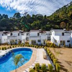 White chalets and swimming pool at 3R Stays in Bhowali