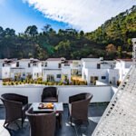 Terrace seating overlooking chalets and wooded hills at 3R Stays